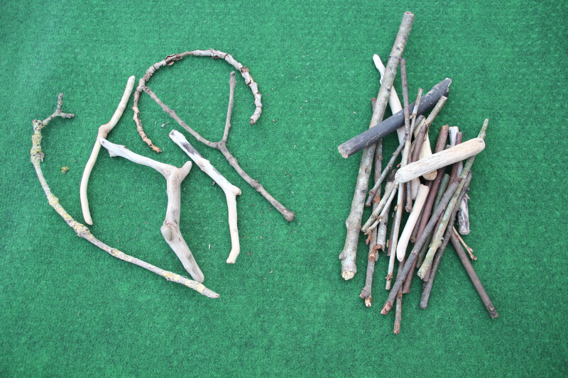 outdoor maths sticks sorted into straight not straight for division by four activity